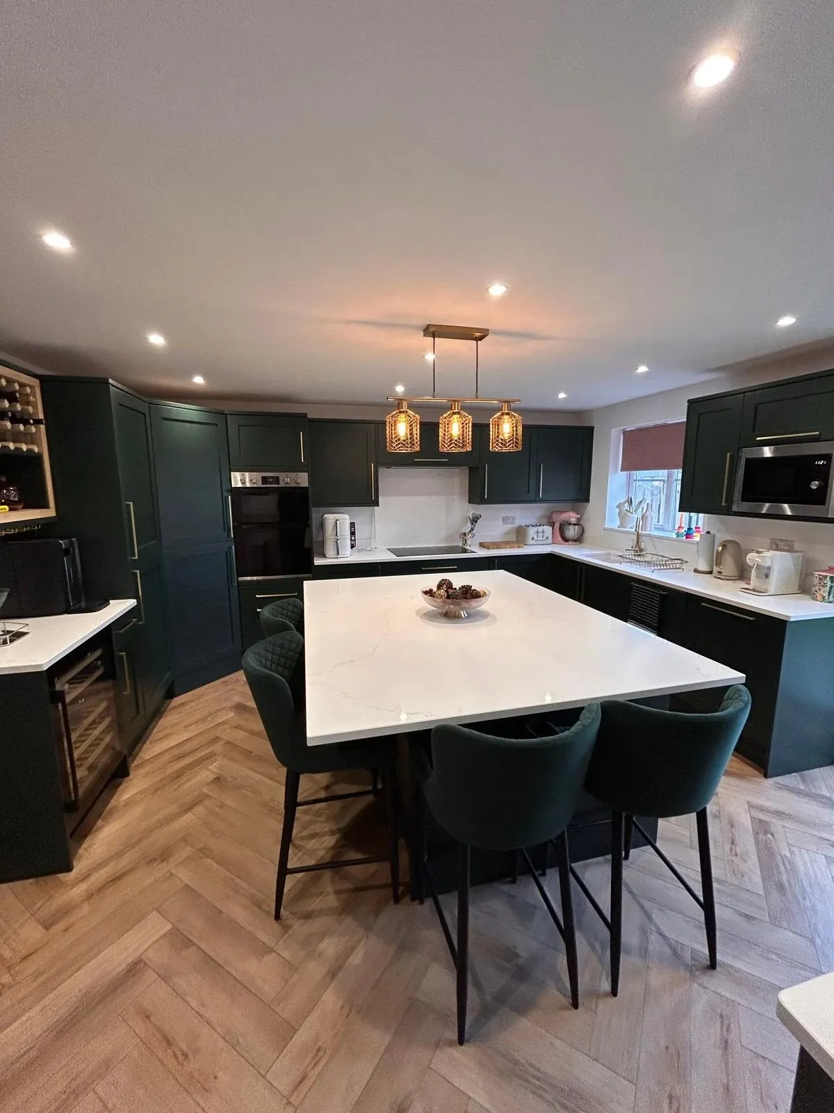Open-plan Hunter Green shaker kitchen with large quartz island