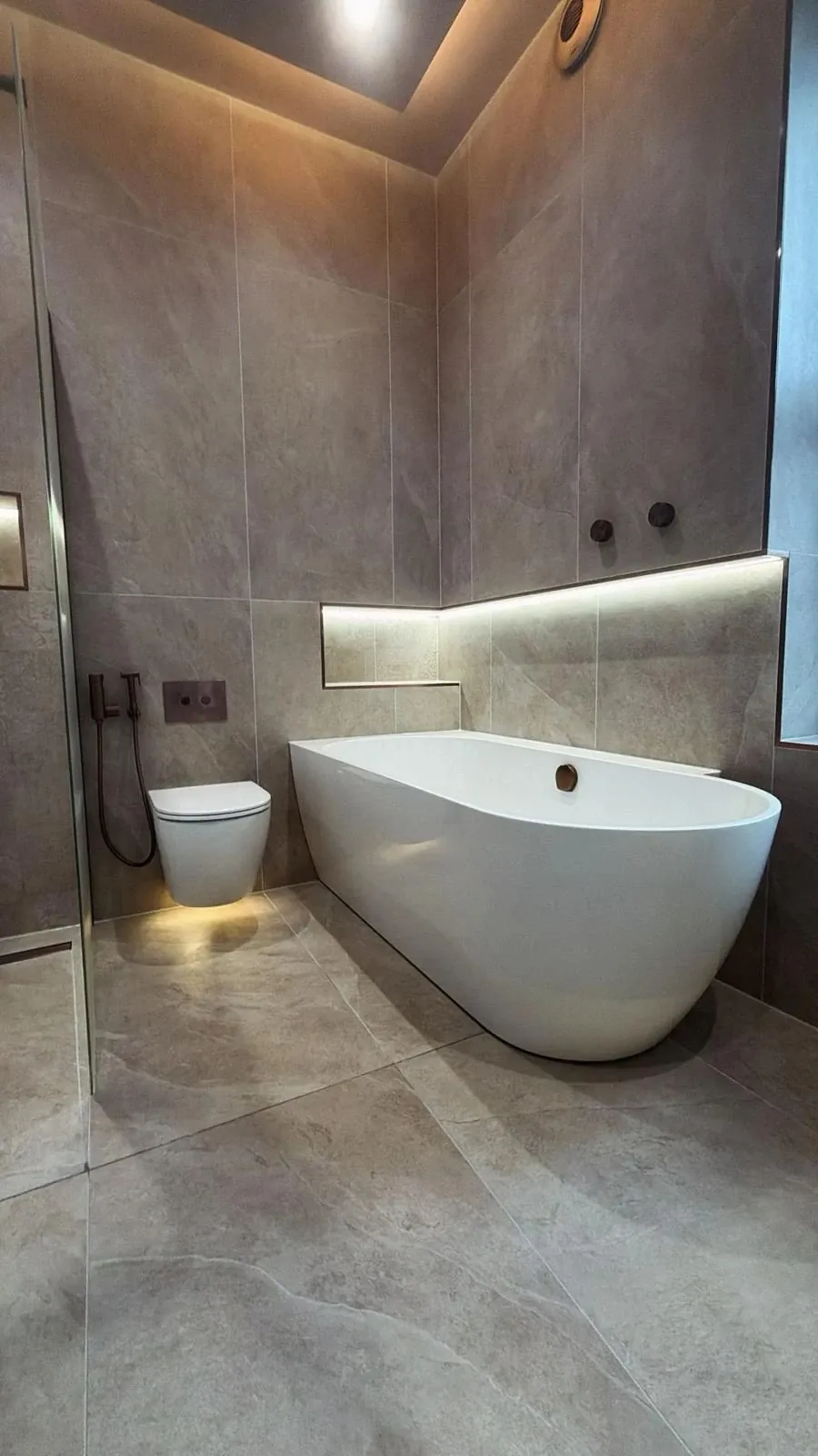 Freestanding bath with lit niche and Italian porcelain tiles